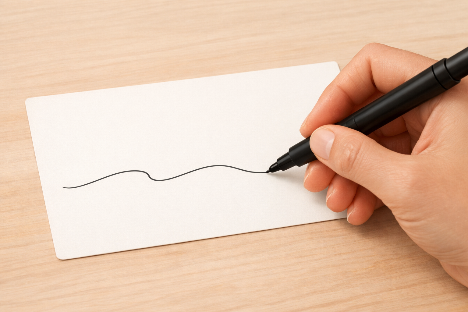 Hand writing a single large term on the front of a flashcard.