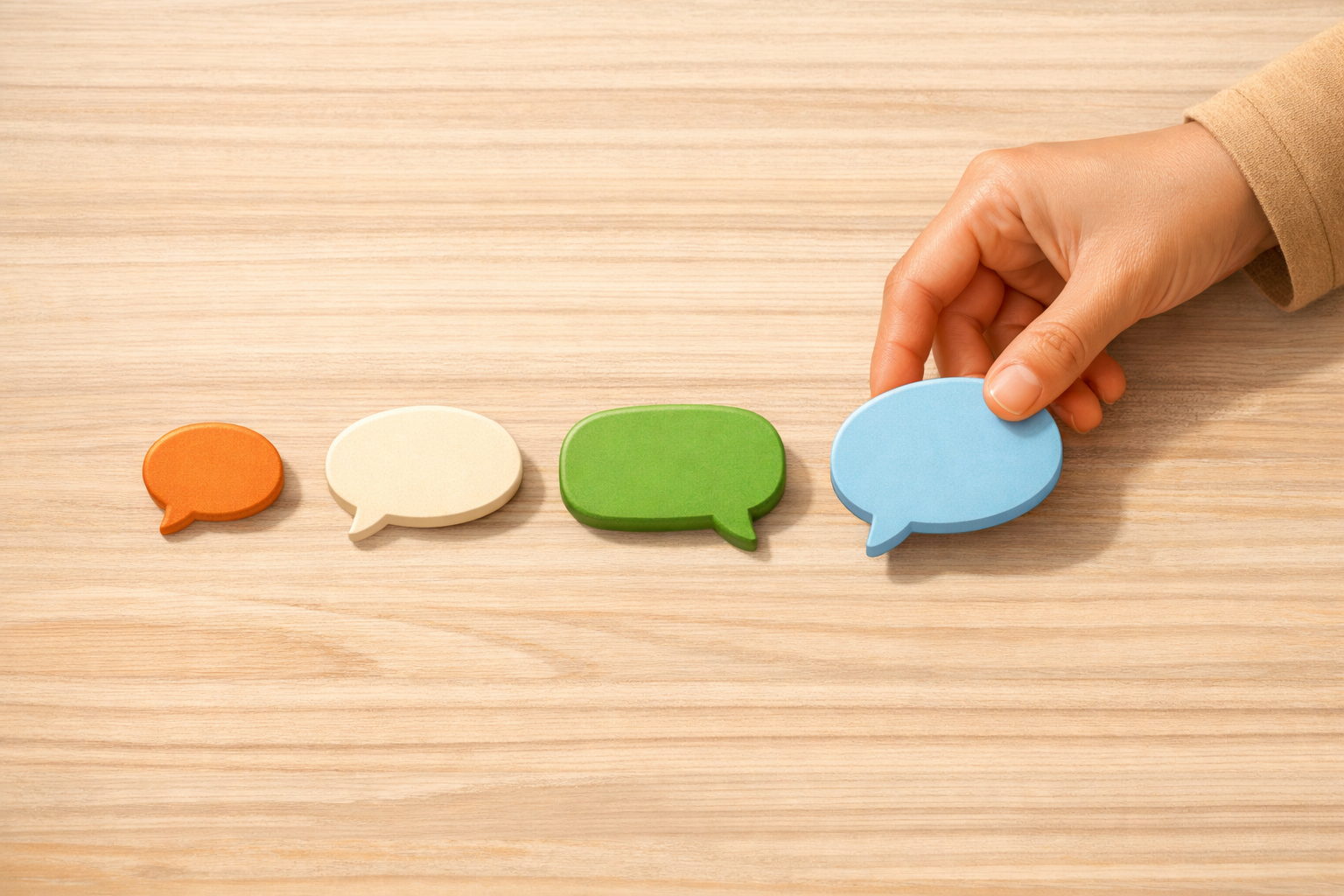 Hand arranging a few small speech bubbles in a simple sequence to represent a short dialogue.
